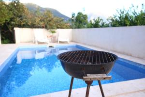 a barbecue grill next to a swimming pool at Lemon Villa in Bar