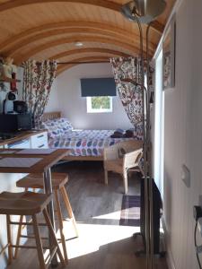 CarleenThe Shepherd Hut的房间里有一张床和一张桌子的卧室
