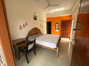 a bedroom with a bed and a desk and a chair at Mattuppavu Beach House in Vilinjam
