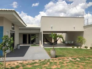 ein weißes Haus mit Palmen im Hof in der Unterkunft Sua casa fora de casa, ao lado do shopping in Jacuda