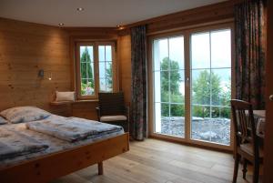 a bedroom with a bed and a large window at Jobin Brienz in Brienz