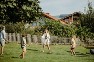 a woman and two children playing with a ball in a yard at Resl Resort in Flachau +86 photos