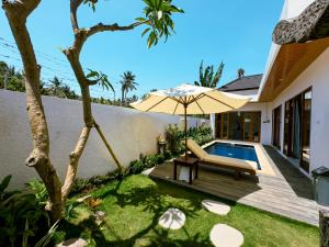 a backyard with a pool and an umbrella at The Arya Villa Lovina in Lovina