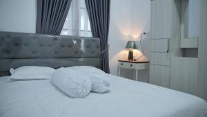 a bedroom with a white bed with white pillows at Aljazeera Residence in Lamnyong