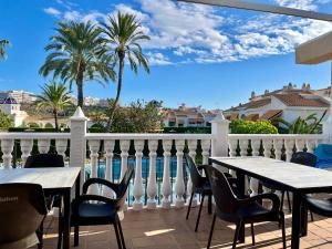 a balcony with tables and chairs and a pool at Townhouse med takterrass i Costa Hispania in Gran Alacant