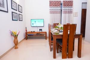 a dining room with a table and chairs and a television at Square One HEIGHTS- Kiribathgoda Kelaniya in Kiribathgoda