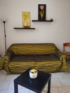 un sofá a rayas en una sala de estar con mesa en Careggi Apartment, en Florencia