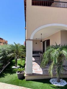 a courtyard with palm trees in a building at HomeStyle Agorà in Villasimius