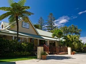 a building with a palm tree in front of it at Governors Lodge Resort Hotel in Burnt Pine