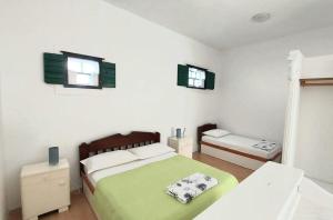 a white bedroom with a bed and two windows at Apartment Brane in Bol