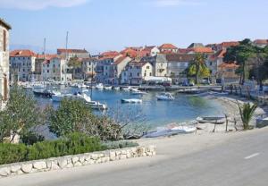 a group of boats in a river with buildings at Apartments Paulina in Postira
