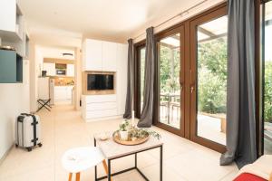 a living room with a table and a tv at VSG Resort - Relaxing Apartments, 200m from the Sea, with Pool, Sauna & Jacuzzi in Klimno