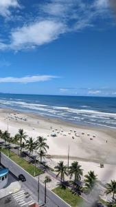 Apartamento Sol Nascente في برايا جراندي: اطلالة على شاطئ به نخل والمحيط +16 صورة