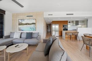 a living room with a couch and a table at Panoramic Ocean Penthouse in Noosa Heads