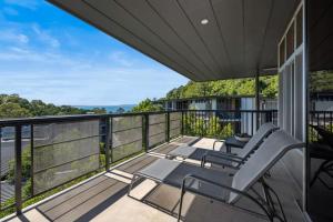 a balcony with two chairs and a view at Panoramic Ocean Penthouse in Noosa Heads