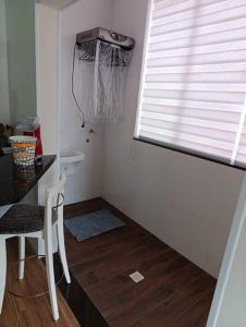 a bathroom with a table and a chair and a window at Residencial Luce Del Sole - Apto N º 1 in Joinville