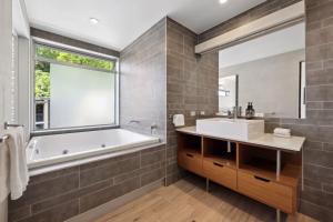 a bathroom with a tub and a sink and a window at Panoramic Ocean Penthouse in Noosa Heads +21 photos