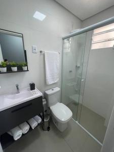 a bathroom with a toilet and a sink and a shower at Loft Studio 101 em São José à 7km de Floripa in São José +13 photos