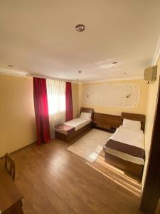a small room with two beds and a table at Sky Luxe Hotel in Astana +12 photos