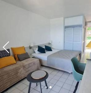 ein Schlafzimmer mit einem großen Bett und einem Sofa in der Unterkunft Studio vue mer, accès piscine in Le Diamant + 2 Fotos