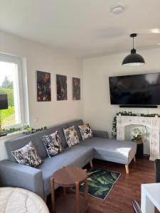 a living room with a couch and a tv at Zimmer der Welt in Hoppegarten