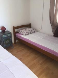 ein Schlafzimmer mit zwei Betten und einem Tisch mit Lampe in der Unterkunft Apartment Tihana in Vir + 6 Fotos