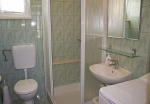 een badkamer met een douche, een toilet en een wastafel bij Apartments Paulina in Postira