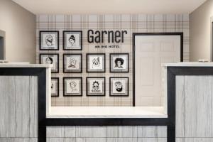 a gallery of framed pictures on a wall in a room at Garner Hotel Aiken South by IHG in Aiken