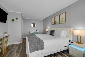 Schlafzimmer mit einem weißen Bett und einem Flachbild-TV in der Unterkunft WINTER RATES! Enjoy Luxurious Oceanfront King Suite! Dogs OK! 1406 in Myrtle Beach + 24 Fotos
