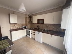 a kitchen with white cabinets and white appliances at Corner splash in Ankara +10 photos
