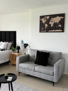 una sala de estar con un sofá y una cama en Umhlanga Minimalist Haven, en Durban