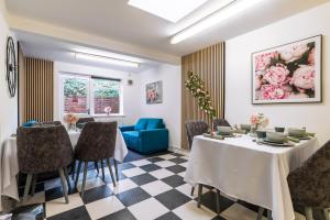 a dining room with two tables and a blue couch at Blossom Retreat in Northampton