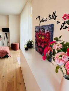 a room with a painting and flowers on a wall at Villa Karmel modern 3 bedroom appartment in Blankenberge