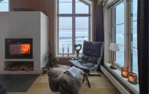 a living room with a chair and a fireplace at Cozy Home In Sjusjøen With Sauna in Sjusjøen