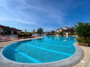 una piscina in un resort con acqua blu di Orchidea Apt - 3 Piscine e un Bar a 200m dal Lago a Desenzano del Garda