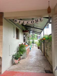- une entrée dans un bâtiment avec un panneau de bienvenue dans l'établissement SHI's Isha Homestay in Coimbatore, à Coimbatore