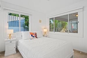 Un dormitorio blanco con una cama y dos ventanas. en Washington 49-Q, en Palm-Eagle Beach 43 fotos más