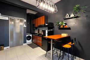 a kitchen with a wooden table and a stove at The YC Nilai Guesthouse in Nilai