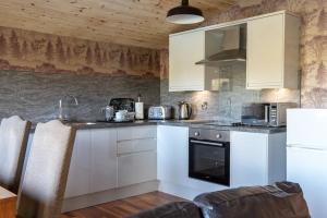 una cucina con mobili bianchi e un piano di lavoro di Harvest 12 Lodge, Yellowtop Country Park a York
