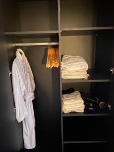 a closet with a white robe and towels at Nw2 Studio Flat mins to London in London