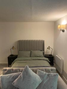 a bedroom with a bed with two pillows on it at Nw2 Studio Flat mins to London in London