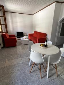 a living room with a table and a red couch at 60s Homestead in Chrysoupolis +9 photos