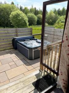 a hot tub sitting on top of a deck at Wild Oats Lodge 17, Yellowtop Country Park in York