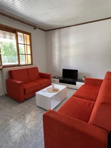 a living room with two red couches and a tv at 60s Homestead in Chrysoupolis