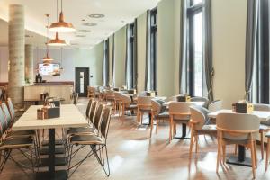 a row of tables and chairs in a restaurant at Holiday Inn - the niu, Yen Hamburg City by IHG in Hamburg