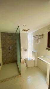 a bathroom with a shower and a toilet and a sink at La Vista Suites Sylhet in Sylhet