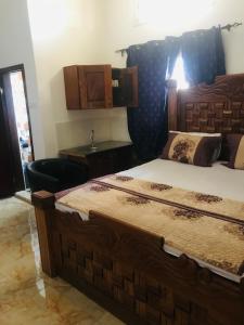 a bedroom with a large bed with a wooden headboard at SunuSal One Bedroom Studio Apartment SS3-CHERNO in Sere Kunda