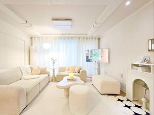 a living room with white furniture and a fireplace at Yeon Stay in Seoul