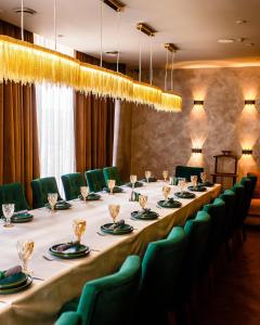 a long table in a room with green chairs at Oasis апартаменты возле Триумфальной арки in Astana