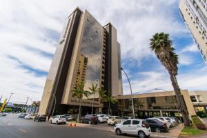 a building with cars parked in a parking lot at BSB STAY Flats Particulares - Cullinan SHN in Brasilia